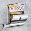 A stainless steel mailbox mounted on a concrete wall, filled with mail including a card and a newspaper. Produktbild-Vorschau