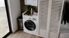 A laundry room with a washing machine and a cabinet. Produktbild-Vorschau