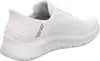 A white Skechers slip-on sneaker shown from the side. Voir les images du produit