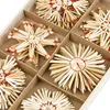 A close-up view of straw star ornaments arranged in a wooden box with dividers. Produktbild-Vorschau