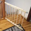 A wooden baby gate installed at the top of a wooden staircase. Voir les images du produit