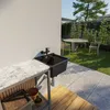 An outdoor sink area with a table and chairs in the background. Anteprima dell’immagine prodotto