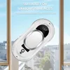 A white window cleaning robot is shown on a window, with a city view in the background. Náhľad obrázku produktu