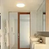 A modern bathroom with a sink, mirror, and a ceiling light. Produktbild-Vorschau