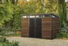 A modern garden shed with wood-effect siding and a sloped roof with windows, situated in a garden setting with paved ground and surrounding greenery. Náhľad obrázku produktu