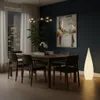 A modern dining room with a table, chairs, and a floor lamp. Produktbild-Vorschau