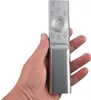A hand holding a silver remote control. Náhľad obrázku produktu
