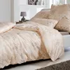 A neatly made bed with a duvet and pillows, featuring a damask pattern. Produktbild-Vorschau