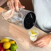 A person is pouring water from a filter jug into a glass with lemon slices. Anteprima dell’immagine prodotto