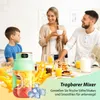 A family of three (father, mother, and son) are at a table with food and drinks, likely having breakfast. A portable blender is prominently displayed in the foreground. Produktbild-Vorschau