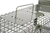 Close-up of a metal trap with a green plate and handle. Produktbild-Vorschau