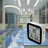 A digital air quality monitor is placed on a desk in a classroom setting. Náhľad obrázku produktu