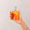 A hand holds a bottle of hair oil. Produktbild-Vorschau