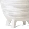 Close-up view of the textured base and legs of a white planter. Produktbild-Vorschau