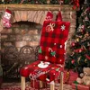 A chair with a Christmas-themed cover is placed in front of a fireplace and a Christmas tree. Náhled obrázku produktu