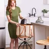 A woman is placing a small appliance into a tote bag in a modern kitchen setting. Anteprima dell’immagine prodotto