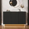 A modern black sideboard with a gold base and a marble-patterned wall behind it. Anteprima dell’immagine prodotto