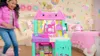 A young girl is playing in a brightly decorated room with a toy kitchen set. Produktbild-Vorschau