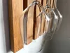 A close-up view of a wooden wine rack with several wine glasses hanging from it. Produktbild-Vorschau