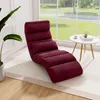 A burgundy floor chair is placed on a rug next to a window with a view of a garden. A small white side table with a book and a cup is nearby. Podgląd zdjęcia produktu