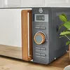 A close-up shot of a modern microwave oven with a white door and a dark gray body, featuring a wooden handle and control panel. Anteprima dell’immagine prodotto