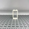 A single white LEGO window frame with a transparent pane, placed on a gray LEGO baseplate. Produktbild-Vorschau