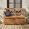 A wooden storage bench with a dark gray cushion sits on a wooden deck in front of a building with a window. Anteprima dell’immagine prodotto