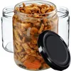 A glass jar filled with preserved mushrooms and carrots, with two empty glass jars and a black lid in the foreground. Podgląd zdjęcia produktu