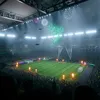 A soccer stadium during a nighttime event with fireworks and drones. Produktbild-Vorschau