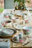 A collection of floral-patterned tableware and glassware arranged on a wooden table. Voir les images du produit