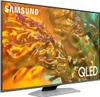 A Samsung QLED TV is shown from a slight angle, displaying a vibrant abstract image on its screen. Produktbild-Vorschau
