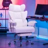 A white gaming chair with a footrest is shown in a room with colorful lighting. Podgląd zdjęcia produktu