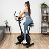 A woman is exercising on a stationary bike in a home gym setting. Náhľad obrázku produktu