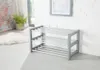 A grey shoe rack with three shelves is shown in a room with a white brick wall and a window. Produktbild-Vorschau