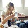 A mother is feeding her baby with a bottle. Voir les images du produit