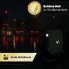 A bicycle bag is shown at night on a wet street with car lights reflecting. Produktbild-Vorschau