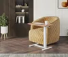 A mobile adjustable height side table is placed next to a plush yellow armchair. Produktbild-Vorschau