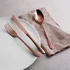 A set of copper-colored cutlery is arranged on a white plate and a linen napkin. Podgląd zdjęcia produktu