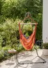 A hammock chair is set up on a patio in a garden setting. Produktbild-Vorschau