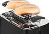 A close-up view of a black toaster with two bread rolls on top. Voir les images du produit