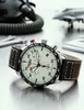 A close-up shot of a pilot's watch with aviation-themed accessories in the background. Náhled obrázku produktu