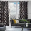A living room scene with a sofa, coffee table, and curtains. Produktbild-Vorschau