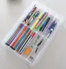 A clear plastic organizer tray filled with various pens, markers, and other stationery items, laid out on a light gray surface. Produktbild-Vorschau