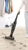 A person is using a cordless vacuum cleaner on a wooden floor with paw prints, in what appears to be a closet area with clothes and shoes. Voir les images du produit