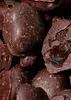 A close-up, overhead view of dark chocolate-covered plums. Produktbild-Vorschau