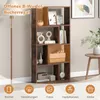 A bookshelf filled with decorative items and books, next to a floor lamp and a side table with a vase of flowers. Podgląd zdjęcia produktu