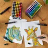 A top-down view of marker pens and coloring pages on a wooden table. Náhľad obrázku produktu