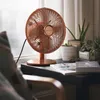 A copper-colored desk fan is placed on a windowsill next to several potted plants and books. Anteprima dell’immagine prodotto
