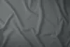A close-up, top-down view of a gray satin bedsheet with soft folds and wrinkles. Náhled obrázku produktu