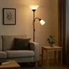 A living room scene with a sofa, floor lamp, and side table. Produktbild-Vorschau